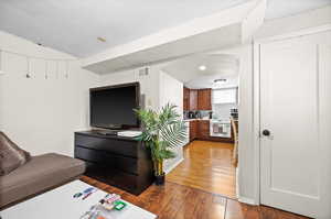 Living area featuring light wood-style floors and arched walkways