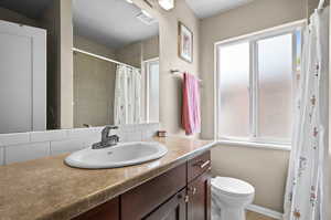 Full bathroom with vanity, decorative backsplash, and a shower with curtain