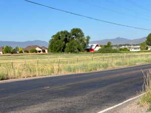 View of asphalt road featuring a mountain view and a view of countryside