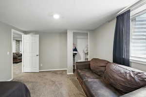 Carpeted bedroom featuring a closet and baseboards