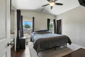 Bedroom with wood finished floors, multiple windows, vaulted ceiling, and ceiling fan