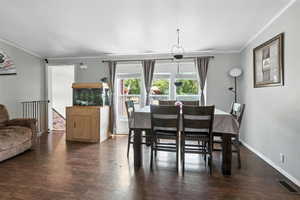 Dining area featuring ornamental molding and wood finished floors