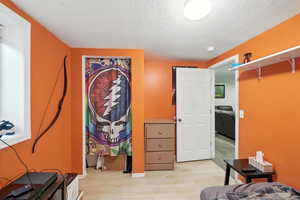 Bedroom featuring a textured ceiling and light wood-style floors