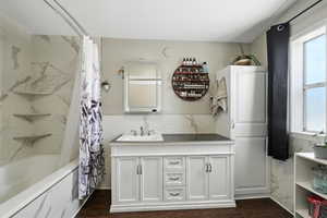 Bathroom featuring vanity, shower / tub combo with curtain, and wood finished floors