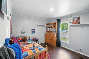 Bedroom featuring baseboards and wood finished floors