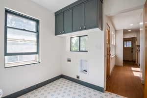 Laundry area featuring hookup for a washing machine, hookup for an electric dryer, cabinet space, recessed lighting, and wood finished floors