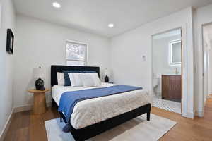 Bedroom featuring light wood-style flooring, recessed lighting, and ensuite bath