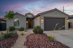 Mediterranean / spanish-style home with a tiled roof, driveway, stucco siding, and an attached garage