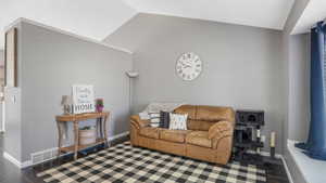 Living room with vaulted ceiling and dark wood-style flooring