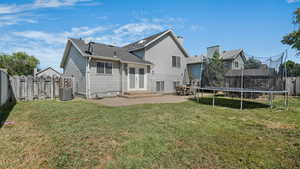Rear view of property featuring a trampoline, french doors, a patio area, and a shingled roof