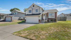 Split level home featuring brick siding, driveway, a garage, and a shingled roof