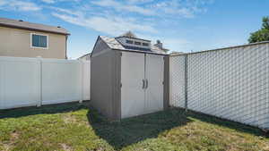 View of shed with a fenced backyard