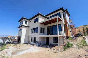 Rear view of house with stucco siding and a mountain view