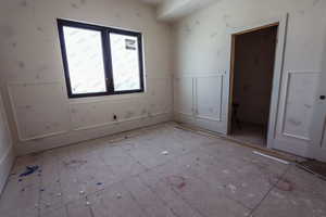 Unfurnished room with a decorative wall and a wainscoted wall
