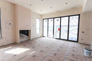 Unfurnished living room featuring a glass covered fireplace