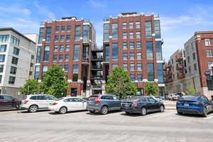 View of building exterior with uncovered parking