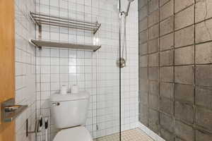 Bathroom featuring a stall shower and tile walls