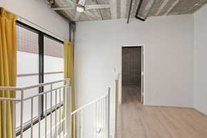 Hall featuring wood finished floors and an upstairs landing