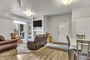Living area with light wood finished floors and a textured ceiling