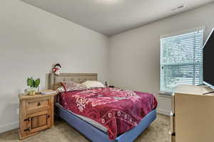 Bedroom featuring light colored carpet and baseboards