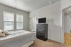 Bedroom featuring baseboards and light carpet