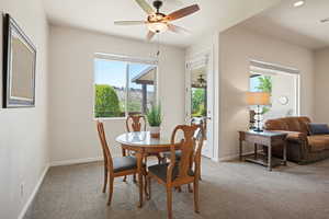 Dining room featuring carpet flooring, healthy amount of natural light, and ceiling fan