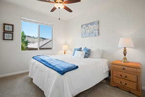Carpeted bedroom with baseboards and ceiling fan