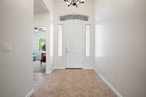 Foyer entrance with a chandelier and baseboards