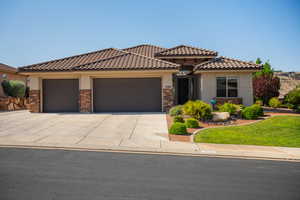 Mediterranean / spanish house featuring a garage, stucco siding, driveway, a tile roof, and a front lawn