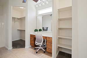 Primary Bathroom featuring ceiling fan, light carpet, light tile patterned floors, built in features, and built in desk