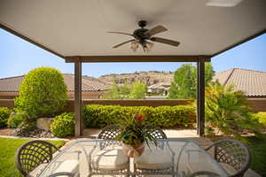 Fenced backyard featuring a ceiling fan, a patio, and outdoor dining area