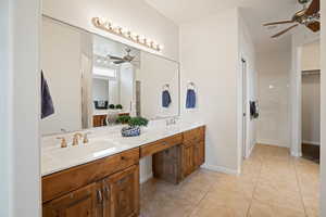 Bathroom featuring a ceiling fan, double vanity, tile patterned floors, and a spacious closet