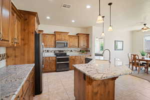 Kitchen featuring stainless steel appliances, a ceiling fan, brown cabinetry, tasteful backsplash, and recessed lighting