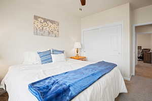 Carpeted bedroom with a closet and a ceiling fan