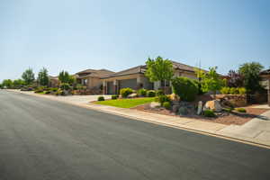 View of front facade featuring a garage, driveway, stucco siding, and a tiled roof