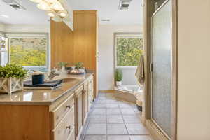 Primary full bathroom with vanity, a bath, a chandelier, and a shower stall