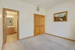 Unfurnished bedroom with carpet and ensuite bath