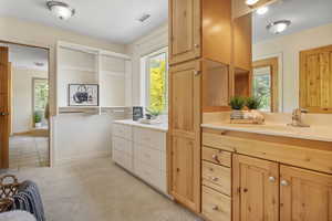 Primary full bath with vanity and baseboards