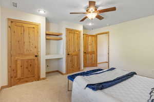 Primary bedroom with ceiling fan and a closet