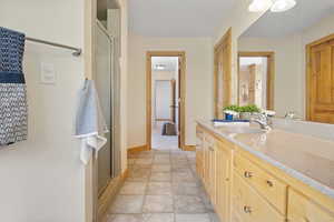 Primary full bath with vanity and a shower stall