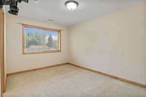 Carpeted empty room featuring baseboards