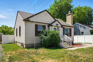 Bungalow-style house with a shingled roof and a chimney