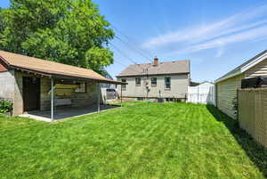 Rear view of house featuring a patio area and a chimney