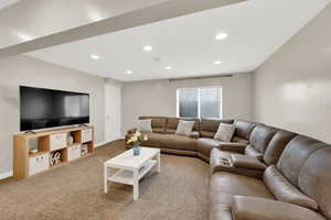 Carpeted living room featuring recessed lighting and baseboards