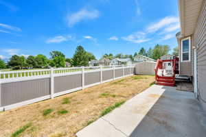 Fenced backyard with a storage unit, a patio, and a residential view
