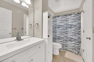 Bathroom with vanity, tile patterned flooring, and a shower with shower curtain