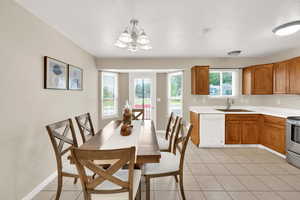 Kitchen with dishwasher, a chandelier, light countertops, and light tile patterned floors