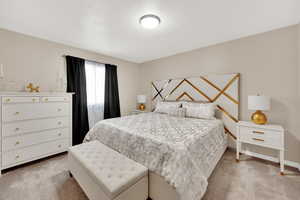Bedroom with light colored carpet and baseboards