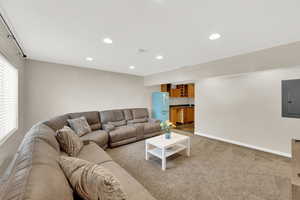 Living room with electric panel, recessed lighting, and carpet