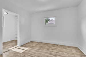 Primary bedroom featuring light wood finished floors and baseboards